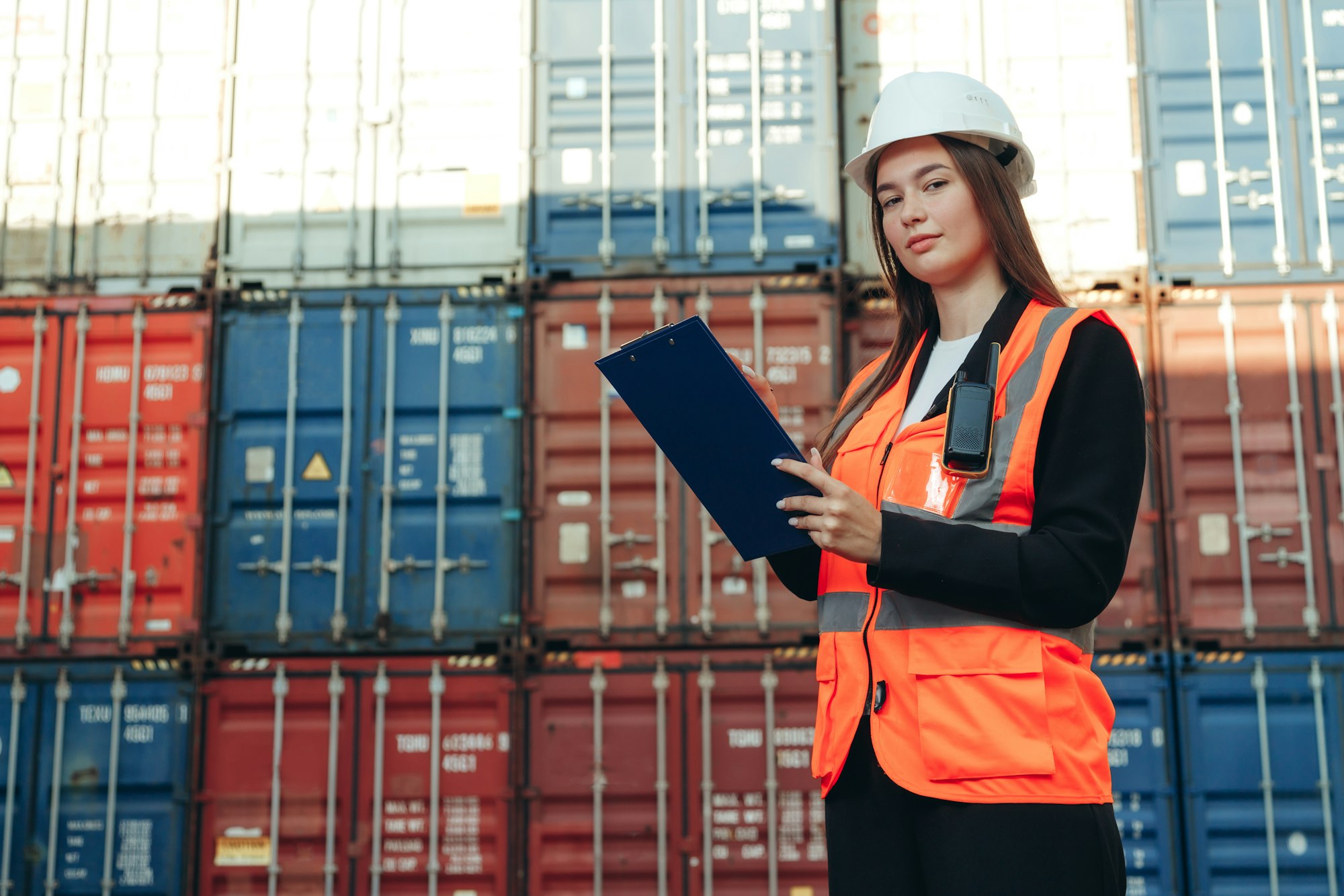 Woman Works in international shipping area Export and import delivery service with containers.